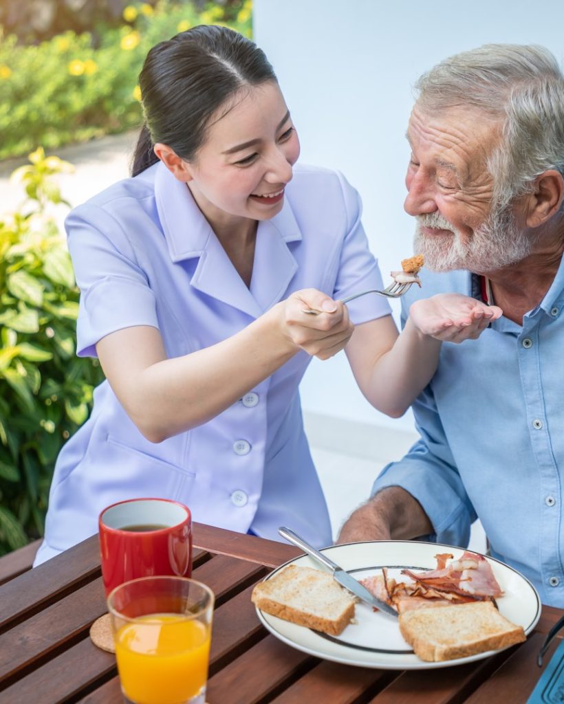 nurse-feeding-elderly-senior-man-eat-breakfast-nursing-home (Large)