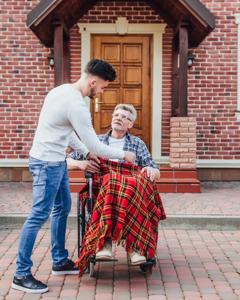 son-helping-his-father-wheelchair-near-nursing-home (Large)